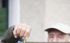 Matsu Winegrower holds a bunch of grapes. Winery Image
